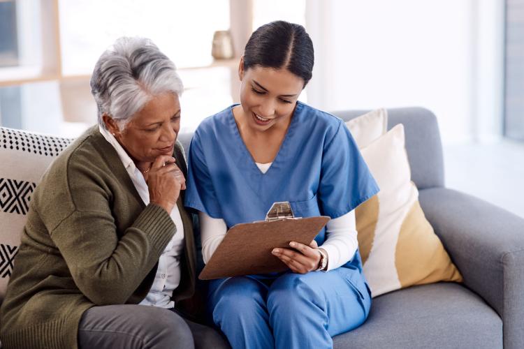 Shot of a young nurse going through paperwork with a senior woman