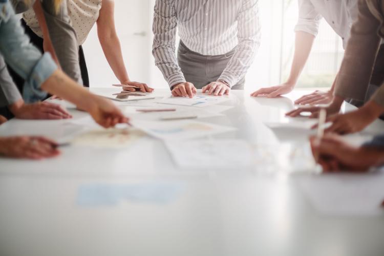 Low angle view of hands of multiracial group of people working with documents on a table