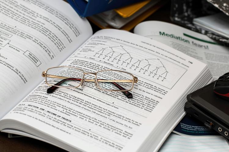 Pair of spectacles placed on an opened book