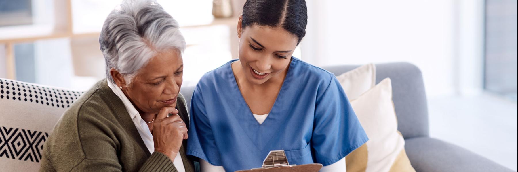 Shot of a young nurse going through paperwork with a senior woman