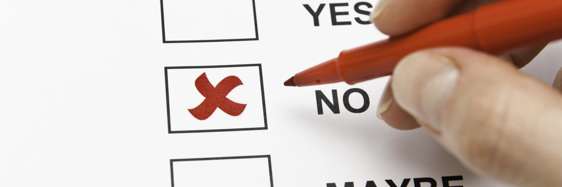 Somebody drawing a cross with a red pen