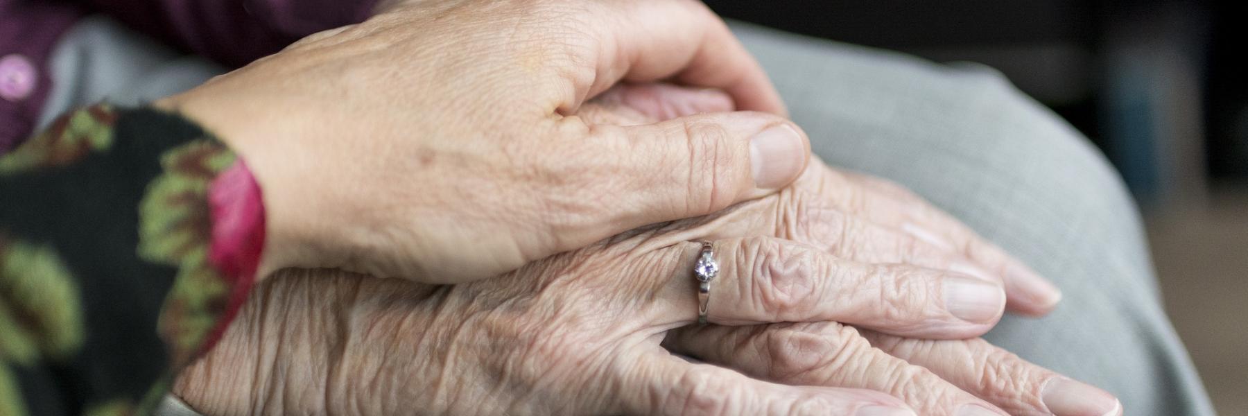 Carer holding patient's hand