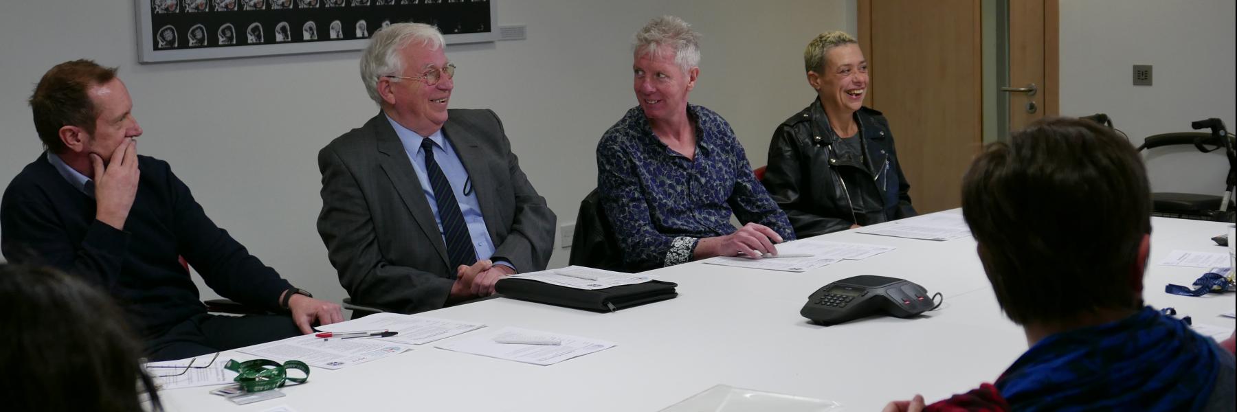 At least 6 people sitting around a board room table.