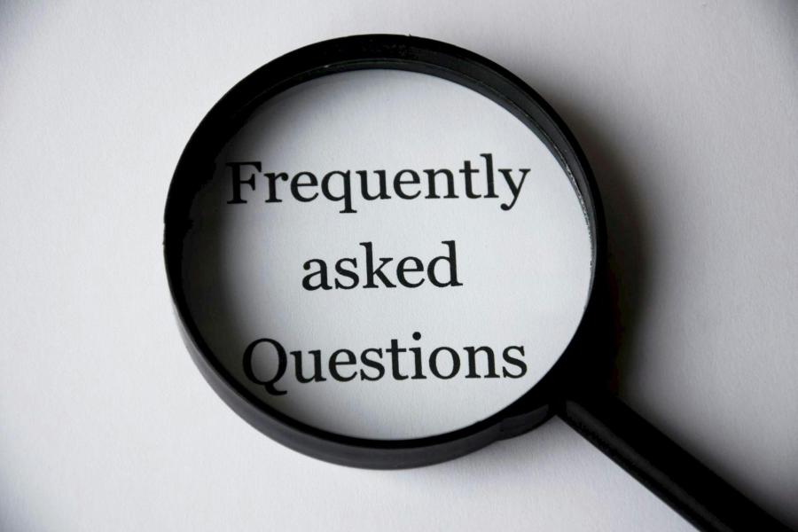 Black magnifying glass positioned over the text 'Frequently Asked Questions'