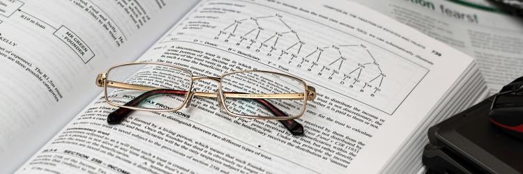 Pair of spectacles placed on an opened book